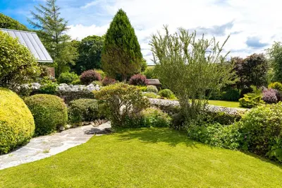 a garden with bushes and trees and a lawn at Ta Mill Holiday Cottages & Lodges -Ta Mill House in Launceston
