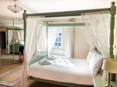 a bedroom with a canopy bed with a window at Ta Mill Holiday Cottages & Lodges -Ta Mill House in Launceston