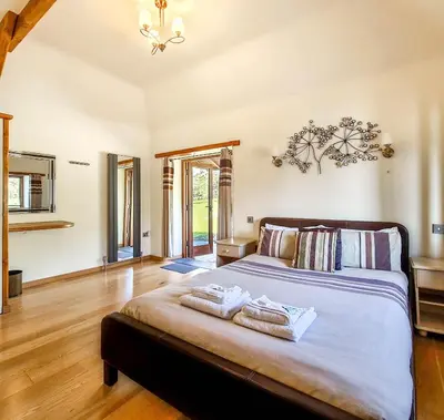 a bedroom with a large bed with two towels on it at Ta Mill Cottages & Lodges - Olde Granary in Launceston