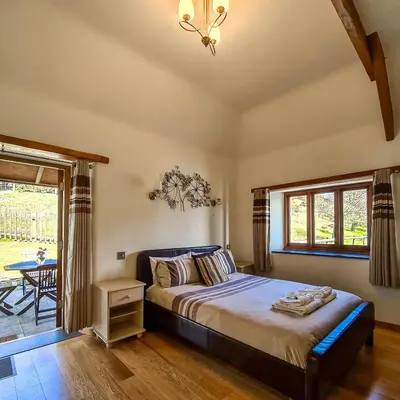 a bedroom with a bed and a table and a window at Ta Mill Cottages & Lodges - Olde Granary in Launceston