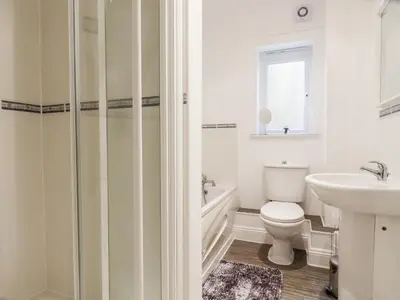 a white bathroom with a toilet and a sink at Flat 2 in Newquay