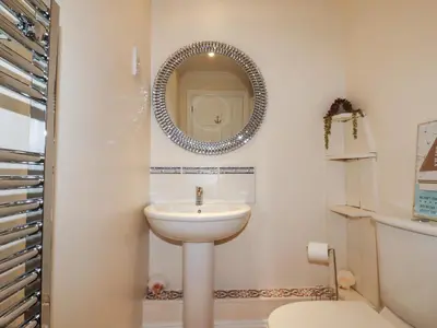 a bathroom with a sink and a mirror on the wall at Flat 2 in Newquay