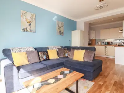a living room with a blue couch and a coffee table at Flat 2 in Newquay