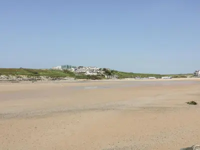 an empty beach with houses in the background at Flat 2 in Newquay