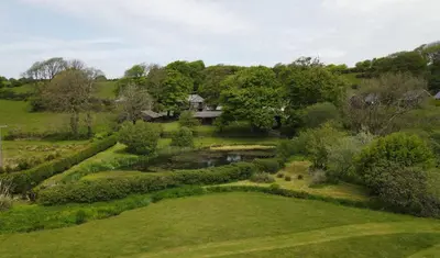 an aerial view of a garden with a house in the background at Ta Mill Cottages & Lodges - Smithy Cottage in Launceston