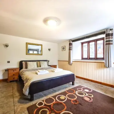 a bedroom with a large bed and a window at Ta Mill Cottages & Lodges - Dairy Cottage in Launceston
