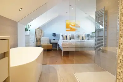 a bathroom with a tub and a bed in a room at Stunning 4 Bedroom Home with Wild Spa, Gym & Hot Tub in Newquay