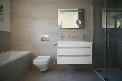 a bathroom with a toilet and a sink and a shower at Stunning 4 Bedroom Home with Wild Spa, Gym & Hot Tub in Newquay