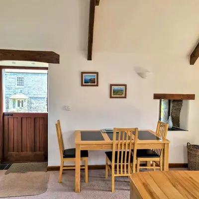 a dining room with a wooden table and chairs at Ta Mill Cottages & Lodges - Hayloft Cottage in Launceston