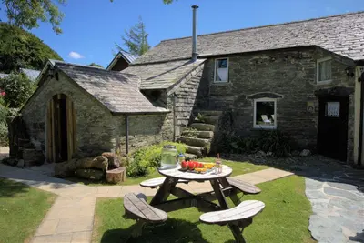 a picnic table in front of a stone house at Ta Mill Cottages & Lodges - Hayloft Cottage in Launceston
