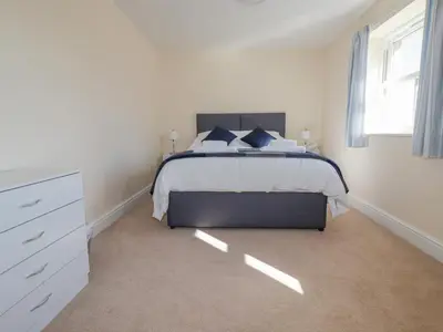a bedroom with a large bed and a window at Ilgram in Newquay