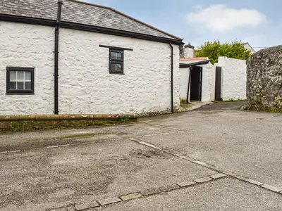 a white building with a window on a street at The Old Barn in Saint Day
