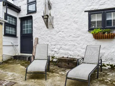 two chairs sitting in front of a building at The Old Barn in Saint Day