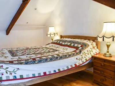a bedroom with a bed and two lamps on a dresser at The Old Barn in Saint Day