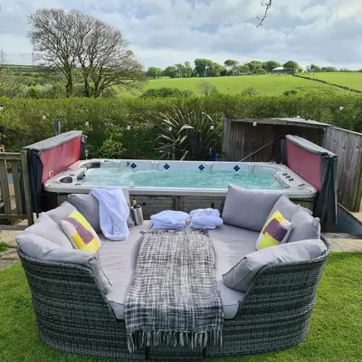 a table and chairs in front of a hot tub at Ta Mill Cottages & Lodges - Meadowview Chalet 2 in Launceston