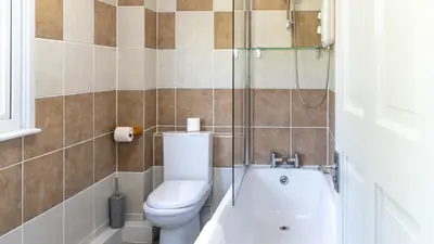 a bathroom with a toilet and a glass shower at Ta Mill Cottages & Lodges - Meadowview Chalet 4 in Launceston