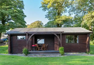 a log cabin with a table in a yard at Ta Mill Cottages & Lodges - Brookview Lodge 2 in Launceston