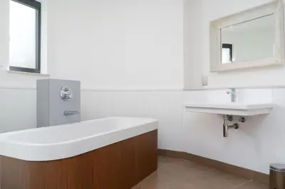 a bathroom with a large white sink and a tub at Jack's Corner in St Ives