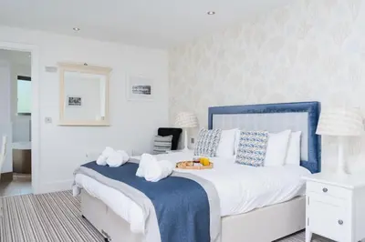 a bedroom with a bed with a tray of towels at Jack's Corner in St Ives