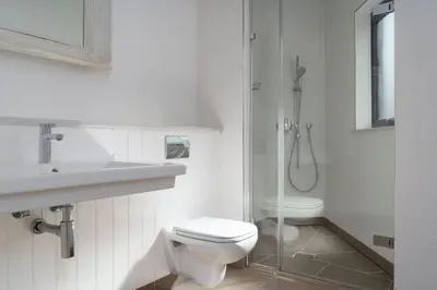 a white bathroom with a toilet and a shower at Jack's Corner in St Ives