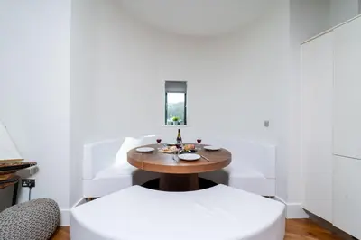 a dining room with a table and two white chairs at Jack's Corner in St Ives