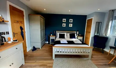 a bedroom with a bed and a blue wall at Stylish coastal retreat in St Ives with parking in St Ives