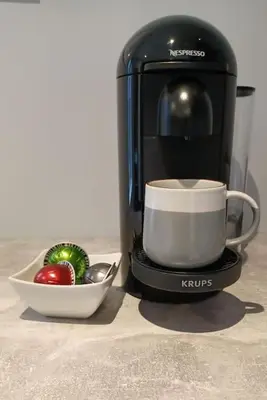 a coffee maker with a cup and a bowl of fruit at Stylish coastal retreat in St Ives with parking in St Ives