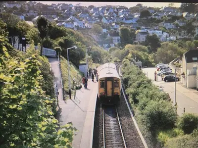 a yellow train on the tracks in a city at Stylish coastal retreat in St Ives with parking in St Ives
