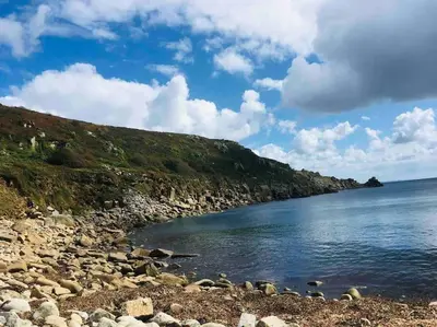 a body of water with a rocky shore at Stylish coastal retreat in St Ives with parking in St Ives