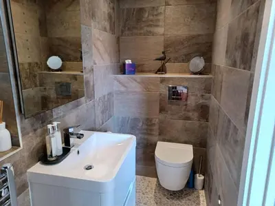 a bathroom with a white sink and a toilet at Stylish coastal retreat in St Ives with parking in St Ives