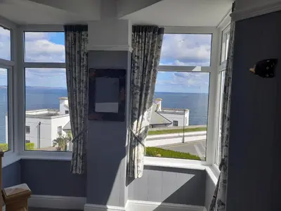 a room with a large window with a view of the ocean at Eddystone Light Apartment in Mevagissey