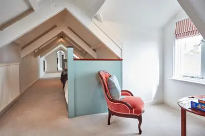 a room with a red chair and a table at Ocean Villas in Marazion