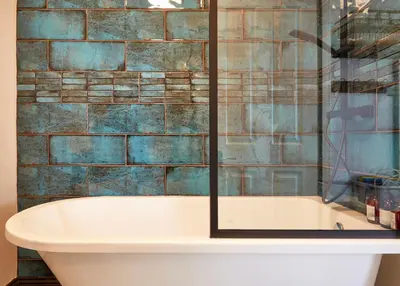 a bathroom with a tub and a glass shower at Ocean Villas in Marazion