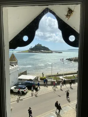 a view from a window of people walking on a street at Ocean Villas in Marazion