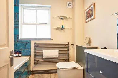 a bathroom with a toilet and a sink and a window at Ocean Villas in Marazion