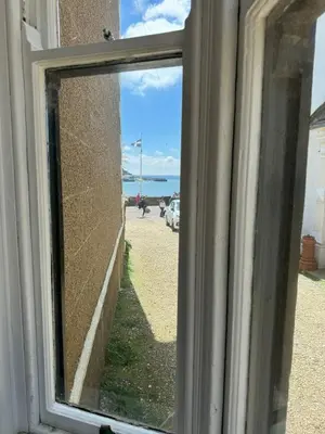 a window with a view of the ocean through it at Ocean Villas in Marazion