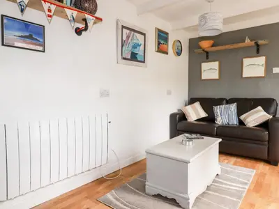 a living room with a couch and a table at The Moonbeach Cabin in Gorran Haven