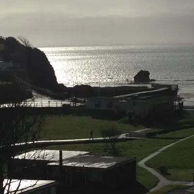 a view of a beach with the sun reflecting on the water at Bay View, Millendreth Looe Cornwall in Looe