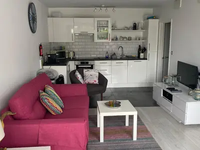 a living room with a red couch and a table at Bay View, Millendreth Looe Cornwall in Looe