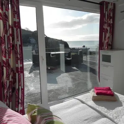 a room with a large window with a view of the ocean at Bay View, Millendreth Looe Cornwall in Looe