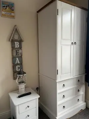 a white dresser and a white cabinet in a room at Seagull Cottage in Looe