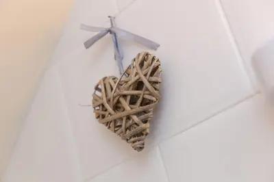 a wooden heart hanging on a wall with a cross at The Annex - Trewolla Cottage in Newquay