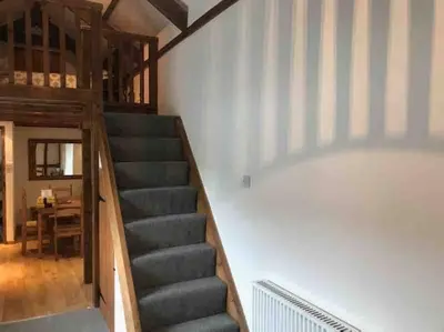 a staircase in a room with a stair case at Woodland cottage in Cornwall with walled garden in Helston