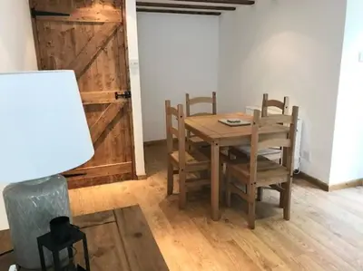a dining room with a table and chairs and a barn door at Woodland cottage in Cornwall with walled garden in Helston