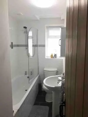 a white bathroom with a sink and a toilet at Woodland cottage in Cornwall with walled garden in Helston