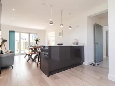 a kitchen with a large black island in a living room at Amal Anpras in Tintagel