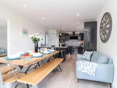 a kitchen and living room with a table and a couch at Amal Anpras in Tintagel