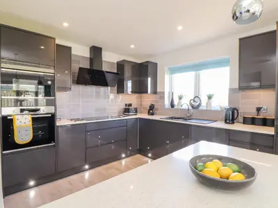 a kitchen with a bowl of fruit on a counter at Amal Anpras in Tintagel