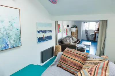 a living room with a couch and a chair at Pollymoor Beach House in Holywell Bay