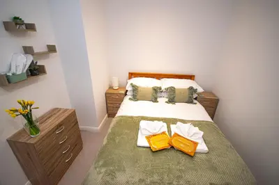 a bedroom with a bed with two towels on it at Lighthouse Lofts - Godrevy in Camborne